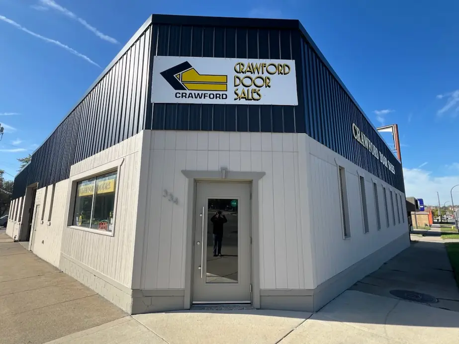The Crawford Door Sales building on East Michigan Avenue, with the yellow chevron sign on a black fascia